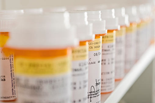 Bouteilles de pilules disposées en étagère dans une pharmacie