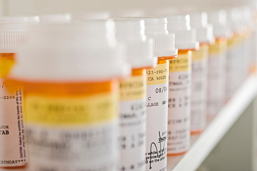 Bottles of pills arranged in shelf at a drugstore